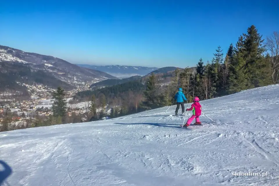 Narciarze na stoku w Szczyrku z widokiem na dolinę