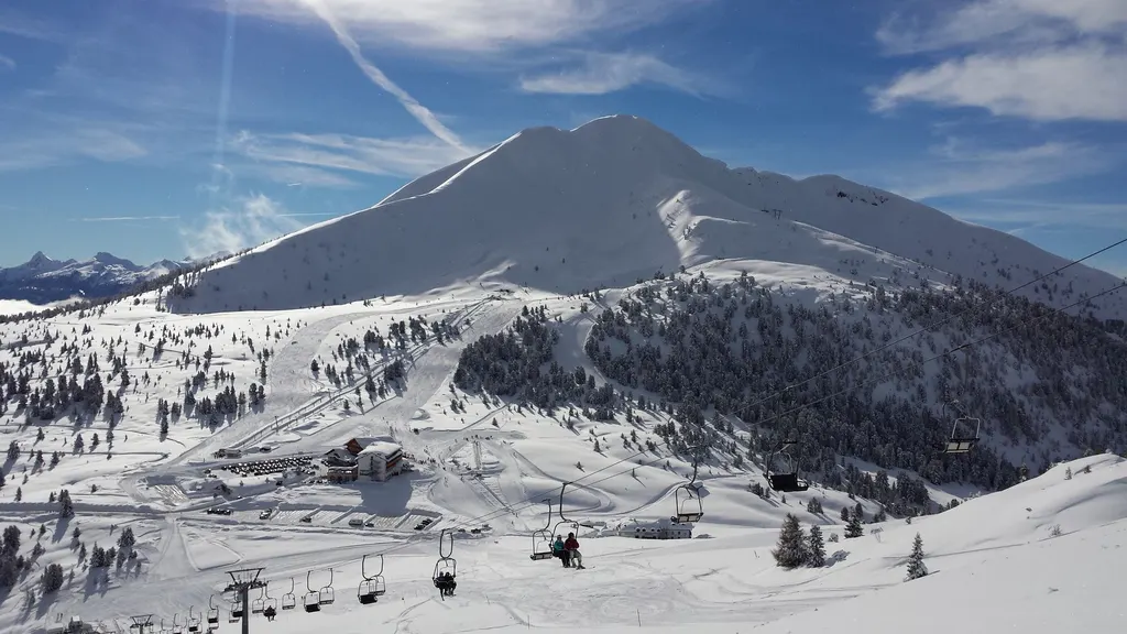 Ośnieżony Schwarzhorn nad przełęczą Oclini, trasy i wyciąg krzesełkowy wśród zaśnieżonych lasów