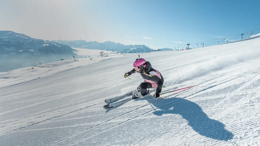 Narciarz na trasie w Hochzillertal, w tle dolina Zillertal