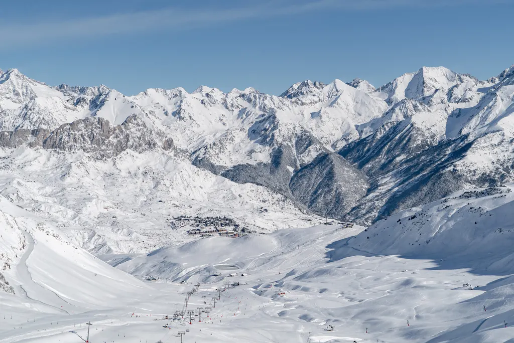 Panorama ośrodka Formigal: trasy i wyciągi w dolinie, osada Formigal i ośnieżone szczyty Pirenejów