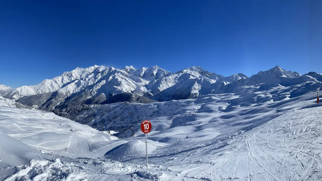 Przygotowane trasy Les Contamines z tyczką trasy nr 10, w tle ośnieżone szczyty masywu Mont Blanc