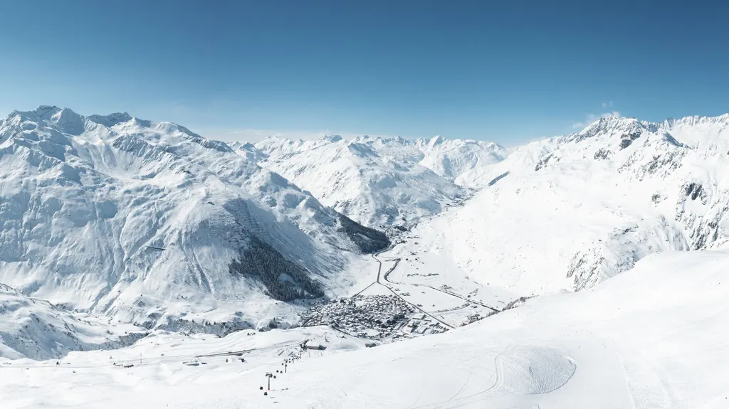 Zaśnieżona dolina Urseren z Andermatt widziana z tras Nätschen, wokół wysokie szczyty Alp