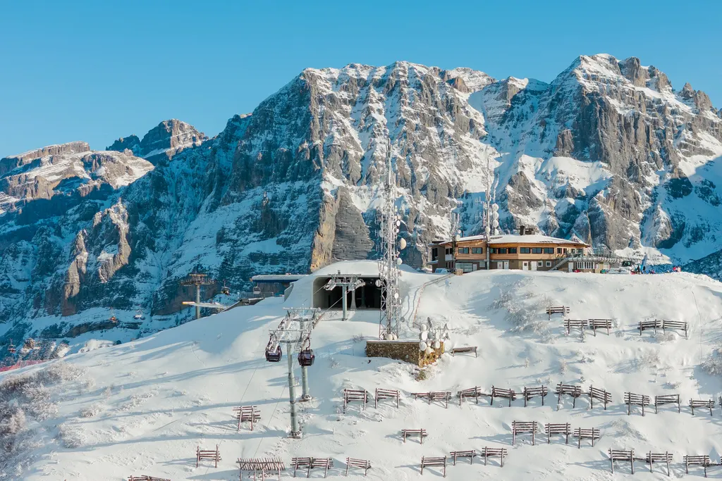 Górna stacja kolei na Doss del Sabion w Pinzolo zimą, w tle skaliste szczyty Dolomitów Brenty