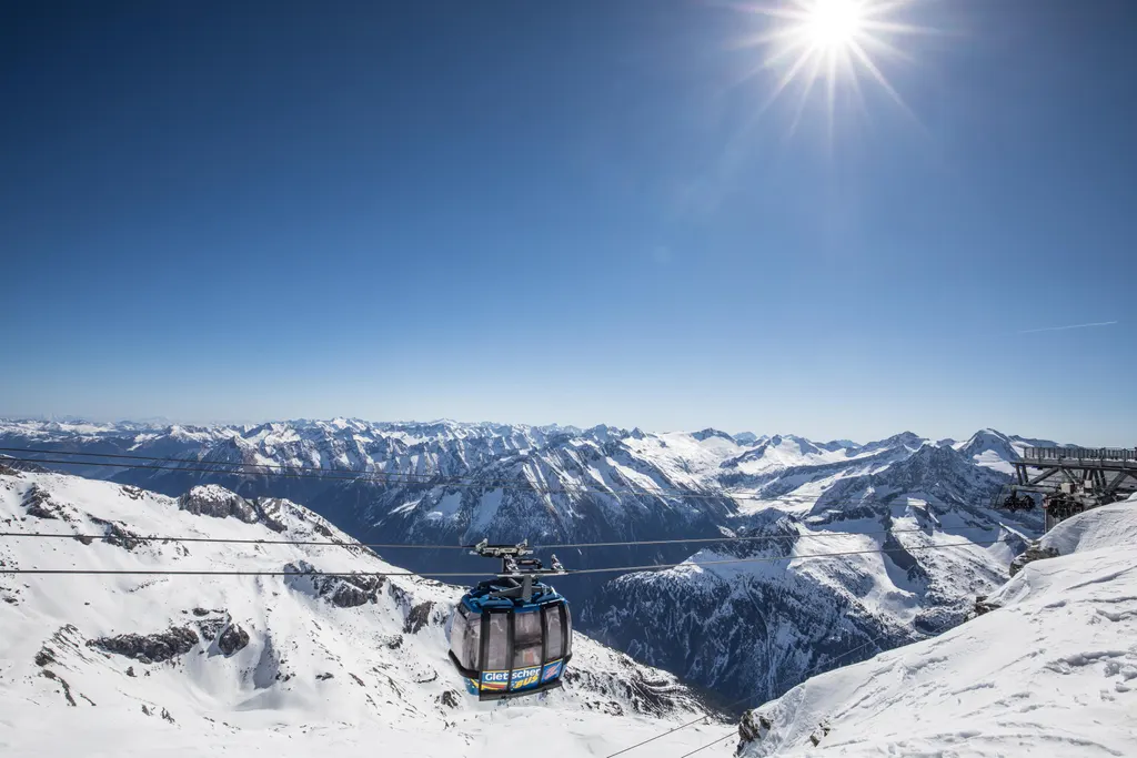 Gondola kolei na lodowcu Hintertux nad ośnieżonym lodowcem, w tle panorama szczytów Alp Zillertalskich