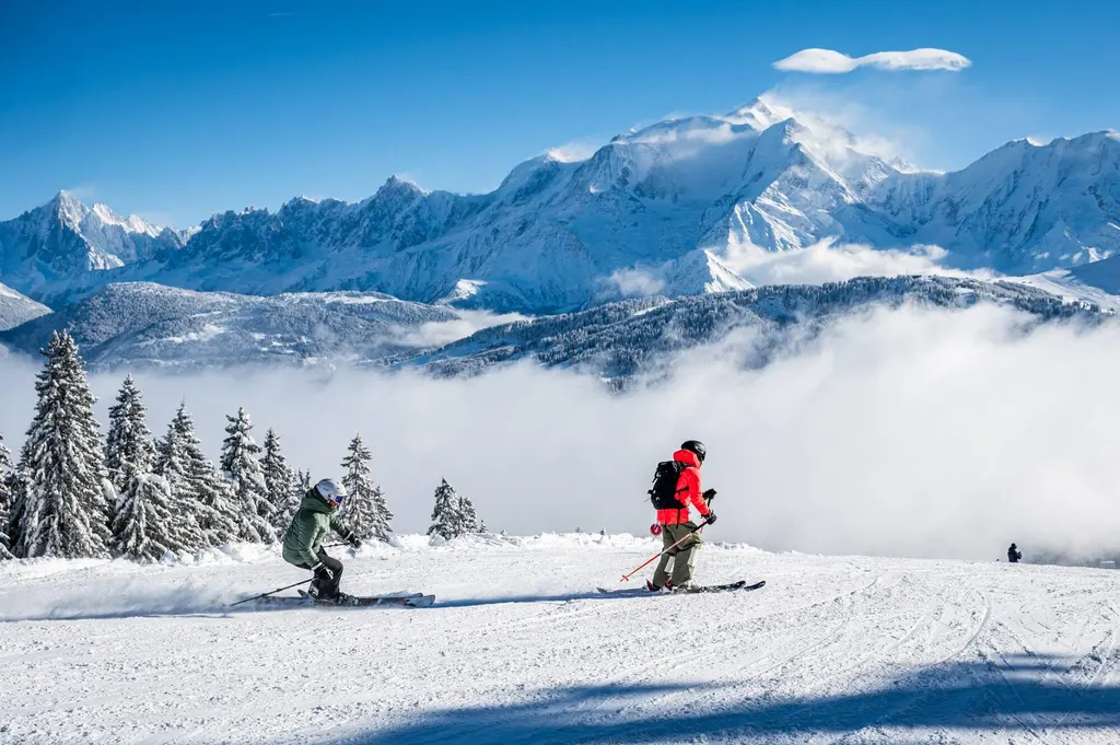 Narciarze na trasie Les Portes du Mont-Blanc w Combloux, nad morzem chmur masyw Mont Blanc