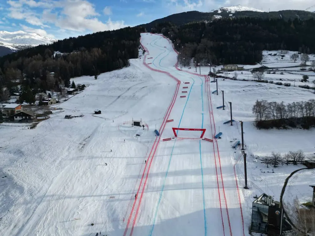 Widok z drona na metę trasy Stelvio w Bormio, ośnieżone stoki, las i szczyty Alp Retyckich