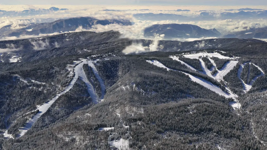 Panorama tras narciarskich Rogli z lotu ptaka wśród lasów Pohorja, w tle morze chmur