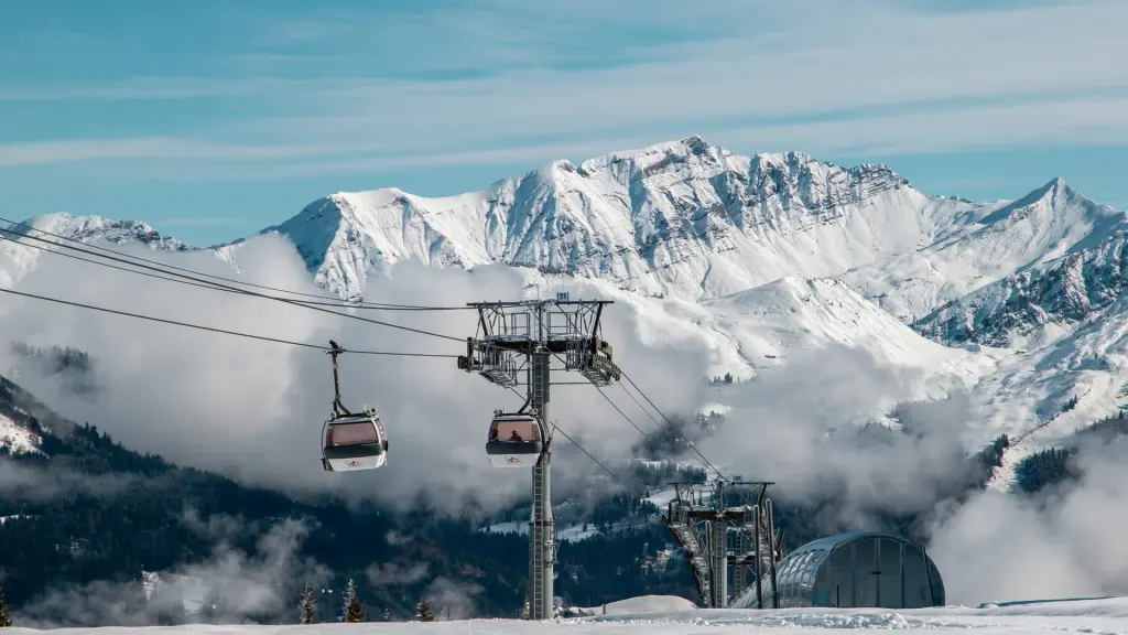 Gondola nad domeną narciarską Samoëns zimą, w tle ośnieżone szczyty masywu Giffre nad chmurami