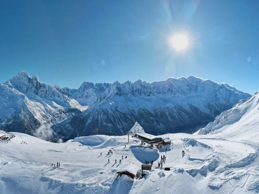 Stacja i stoki La Flégère nad Chamonix zimą, naprzeciw ośnieżony masyw Mont Blanc z iglicami Aiguilles